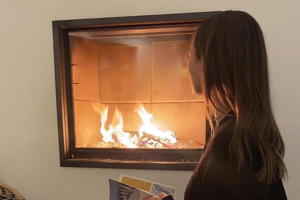 Feu de cheminée en hiver au salon du gîte de luxe dans le Jura Maison atHOme
