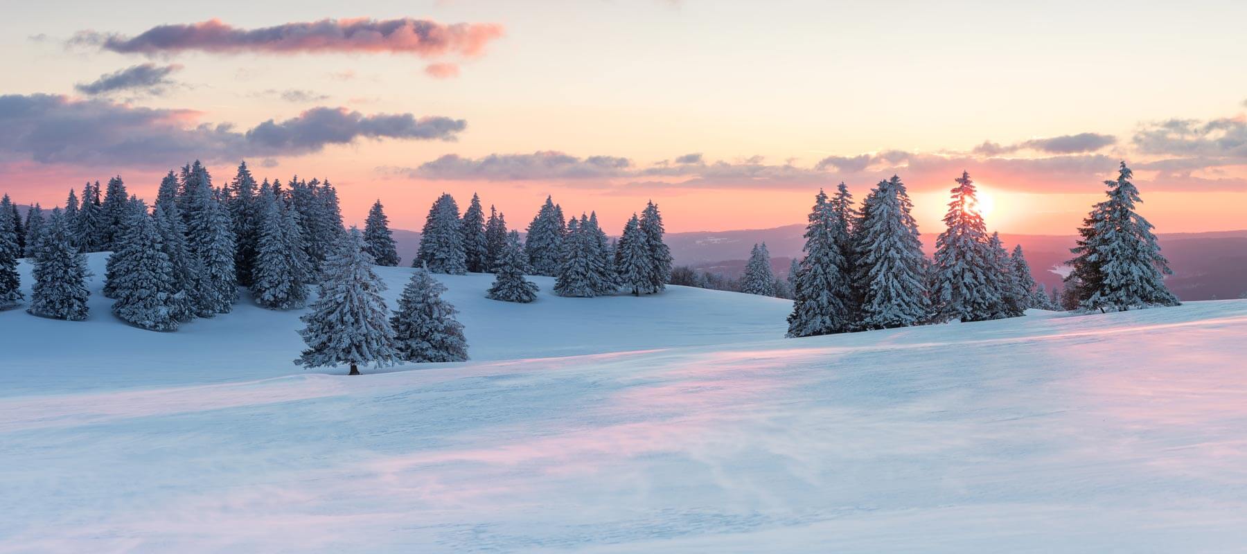 Paysage enneigé du Jura au coucher de Soleil