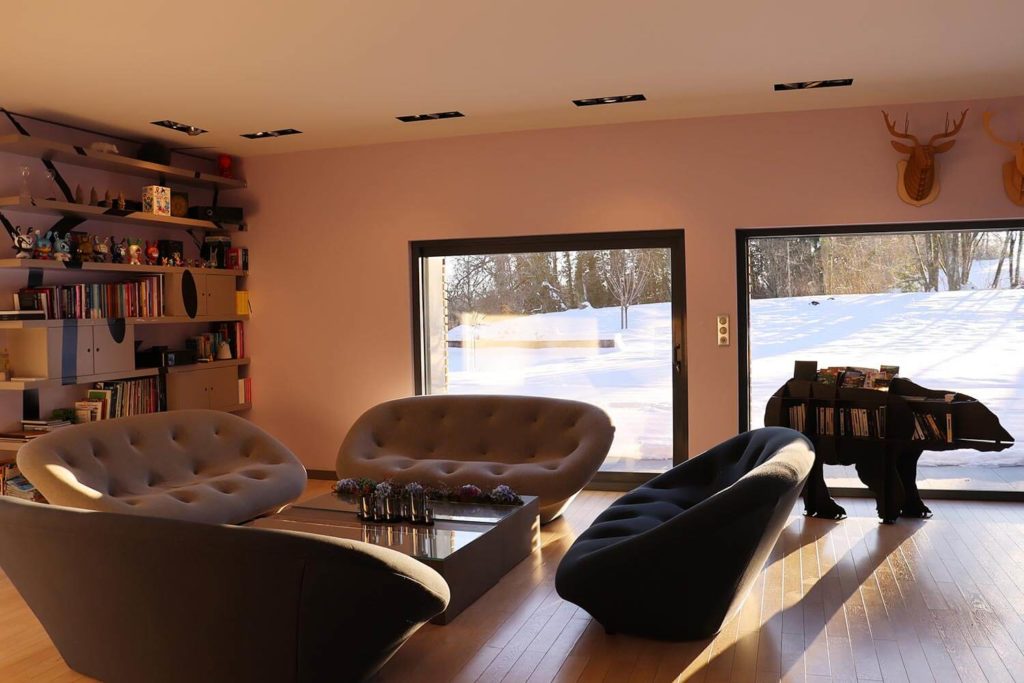 Salon dans le gîte de luxe Maison atHOme dans le Jura avec neige à l'extérieur